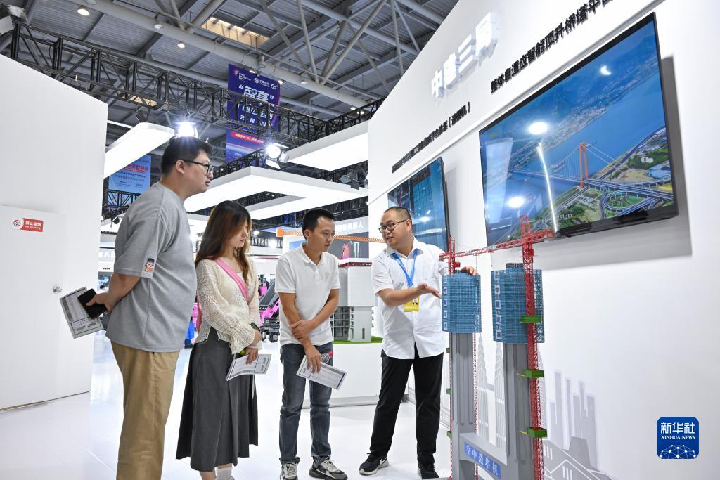 9月4日，觀眾在智博會(huì)上參觀中建三局展示的空中造塔機(jī)。新華社記者 王全超 攝